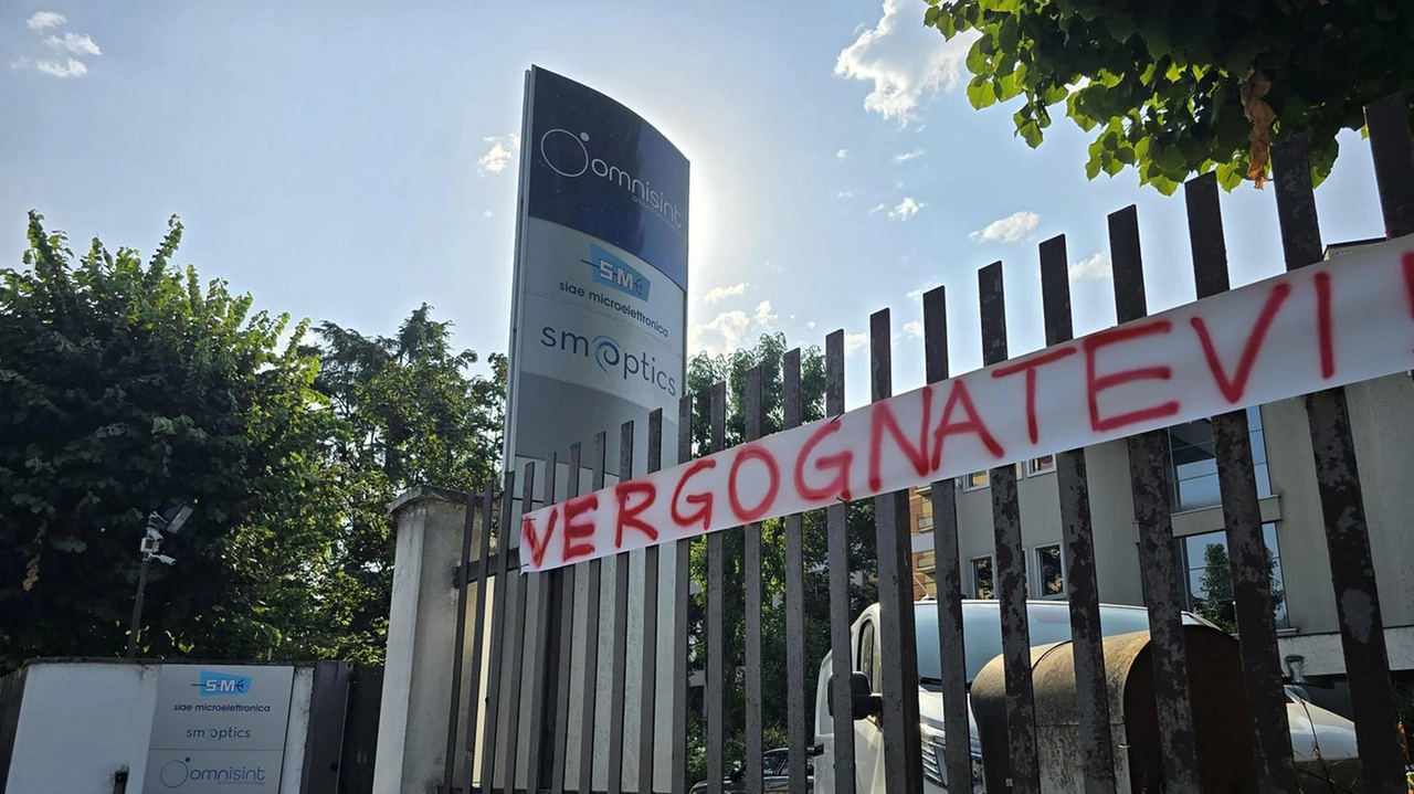 Lo striscione appeso dagli operai a rischio fuori dalla sede di Siae Microelettronica Lo striscione appeso dagli operai a rischio fuori dalla sede di Siae Microelettronica
