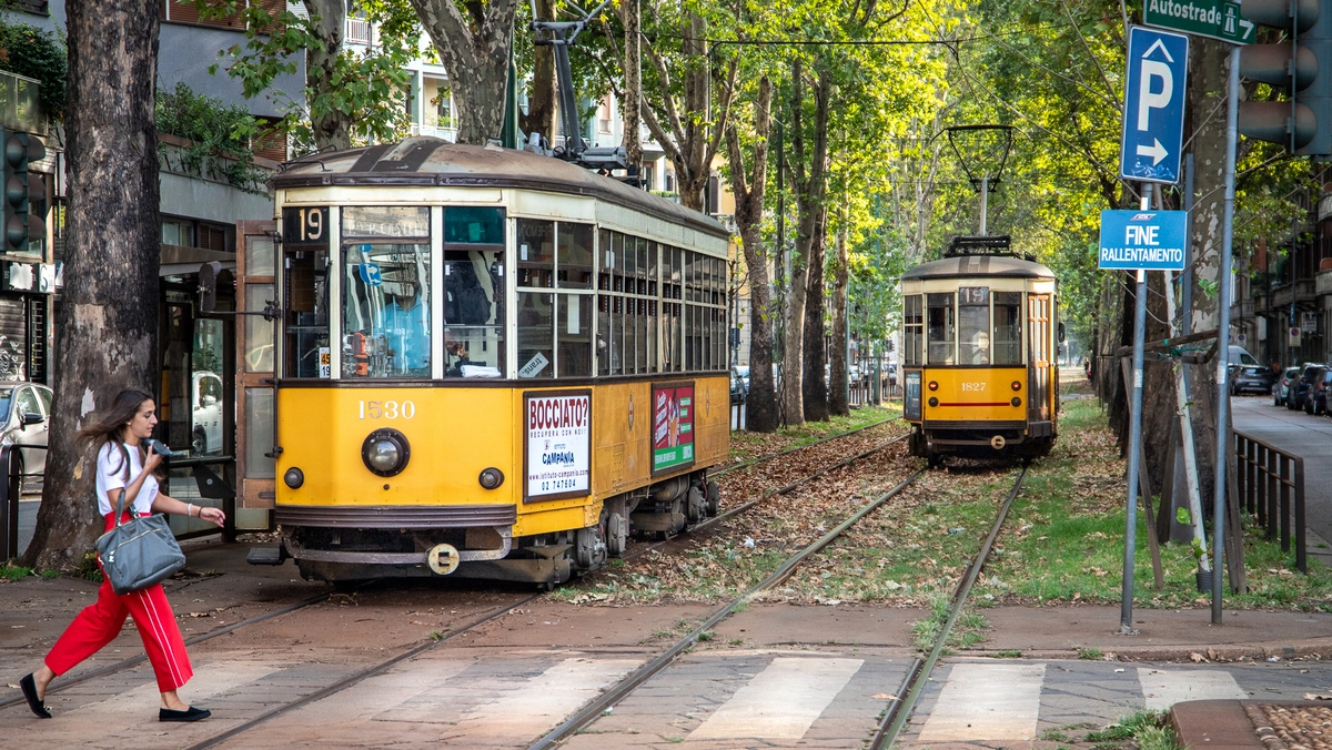 Il tram 19 di passaggio in un viale alberato di Milano