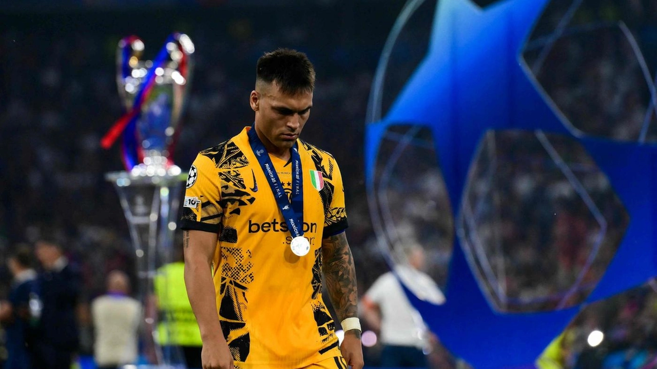 Lautaro Martinez sfila a testa bassa di fianco al trofeo della Champions League
