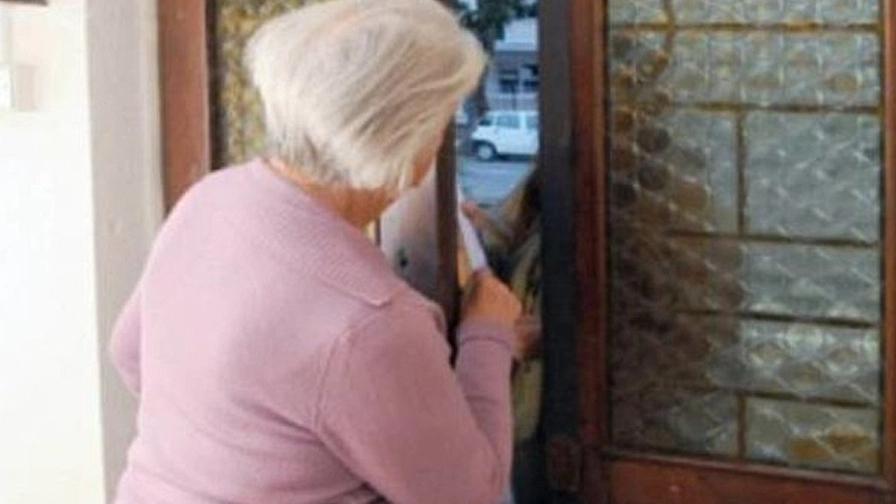 Una anziana apre la porta di casa (foto di archivio)