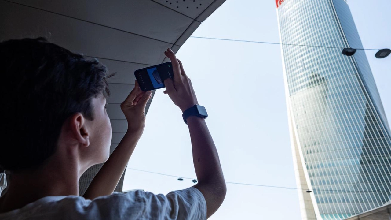 Il viavai di lavoratori, residenti e turisti non si ferma negli spazi accessibili. Sguardi all’insù, verso la scritta che vacilla. "Una fortuna non sia precipitata". Luci e ombre nel quartiere nato per Expo, con negozi, servizi e case di lusso.