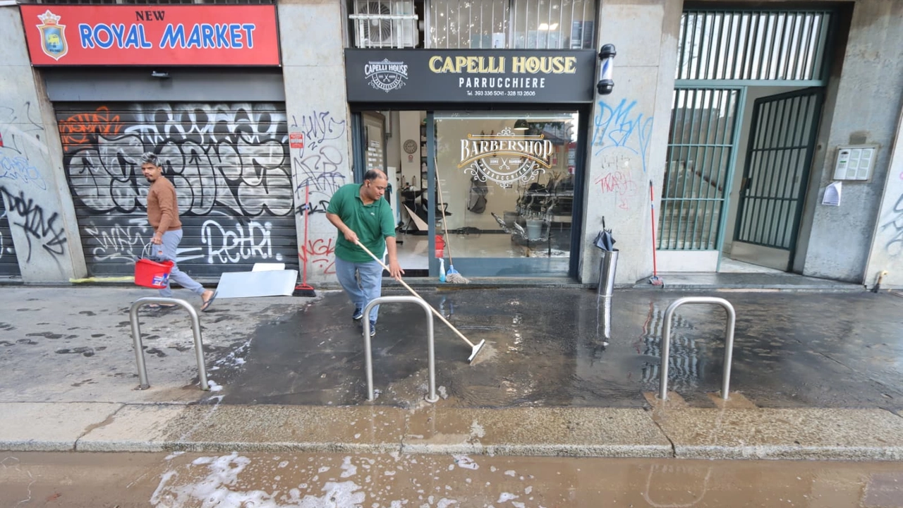 Negozianti impegnati a ripulire dal fango