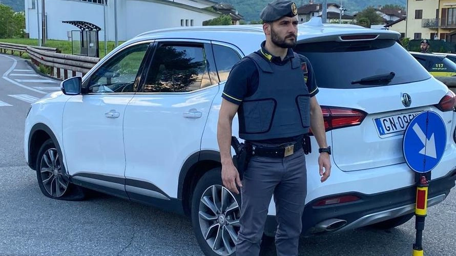 L’auto con lo pneumatico bucato dopo essere stato centrato da due colpi di pistola esplosi dall’arma della Finanza L’auto con lo pneumatico bucato dopo essere stato centrato da due colpi di pistola esplosi dall’arma della Finanza