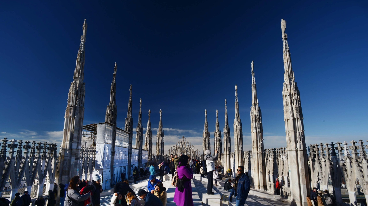 Visitatori sulle terrazze del Duomo per ammirare le guglie e lo skyline di Milano Visitatori sulle terrazze del Duomo per ammirare le guglie e lo skyline di Milano