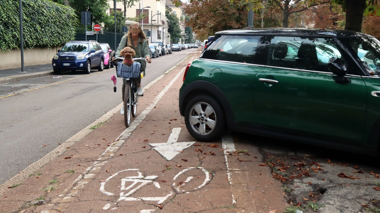 Un'auto intralcia il passaggio delle due ruote su una pista ciclabile Un'auto intralcia il passaggio delle due ruote su una pista ciclabile