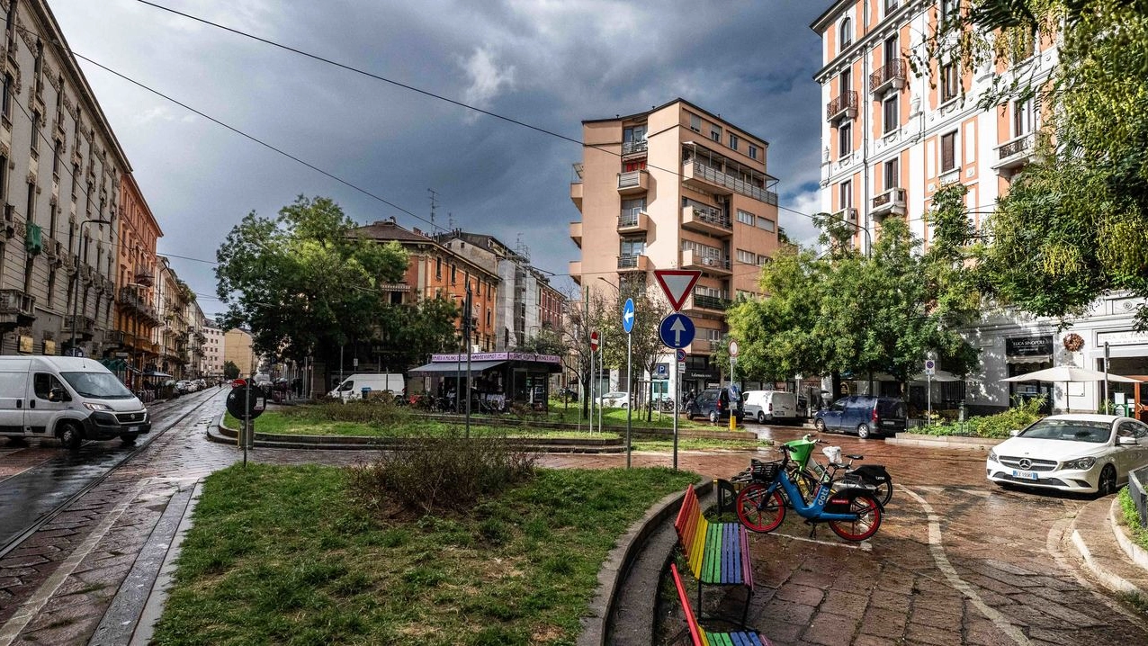 Uno scorcio di piazza Morbegno con le panchine arcobaleno e l’edicola sullo sfondo Uno scorcio di piazza Morbegno con le panchine arcobaleno e l’edicola sullo sfondo