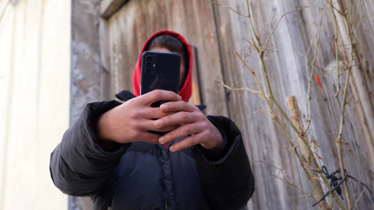 Ragazzino con un cellulare in mano (foto di archivio)