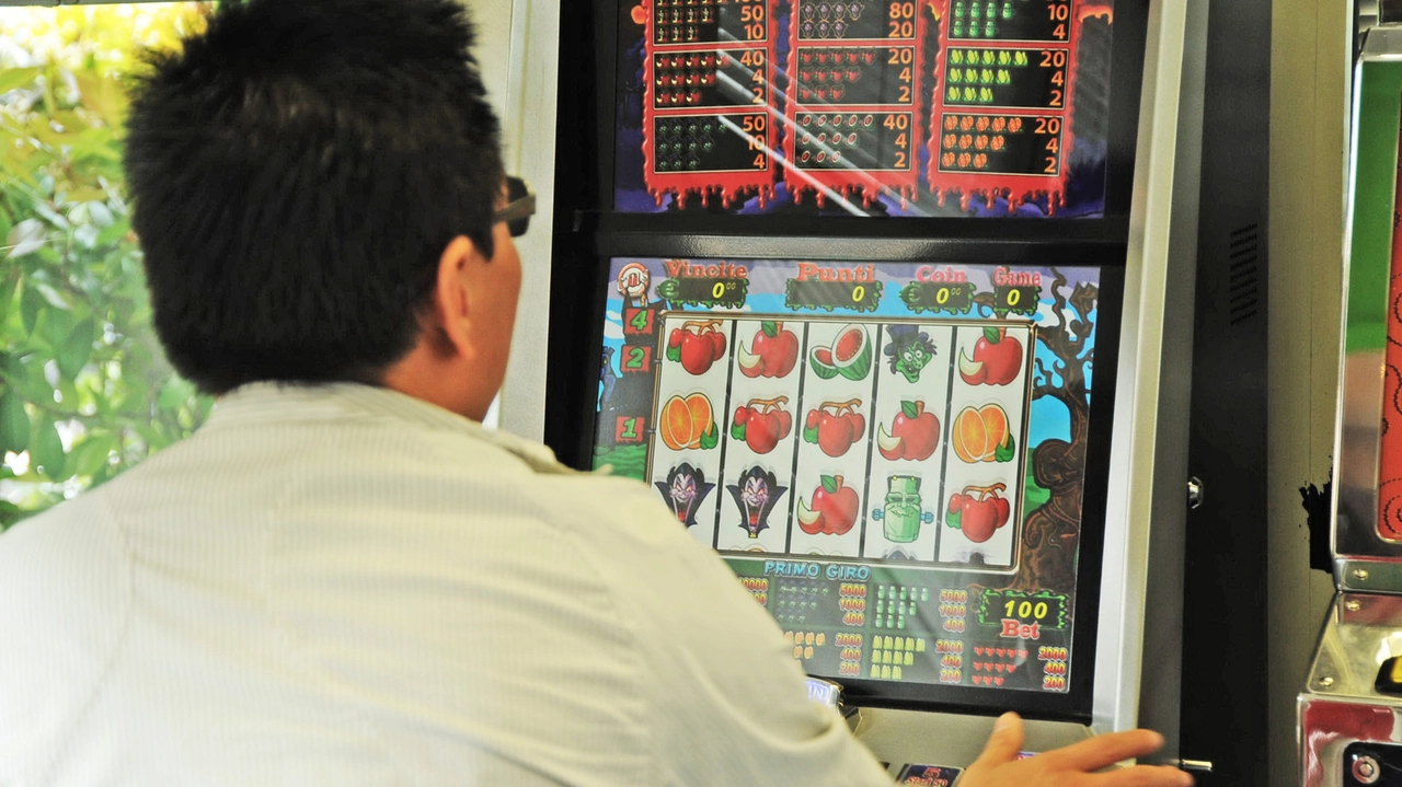 Un giocatore su una slot machine Un giocatore su una slot machine