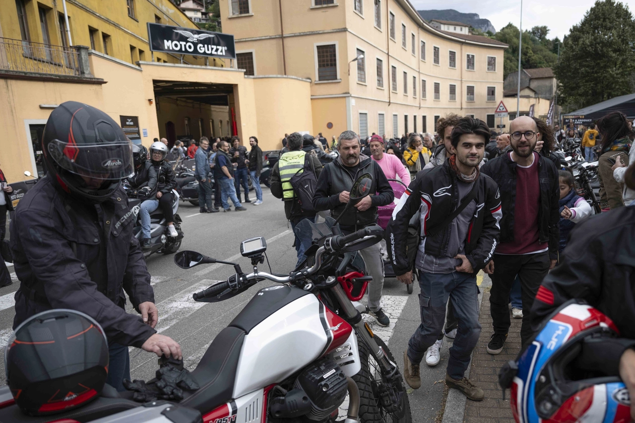 Appassionati guzzisti a Mandello e l'ingresso dello storico stabilimento di via Parodi