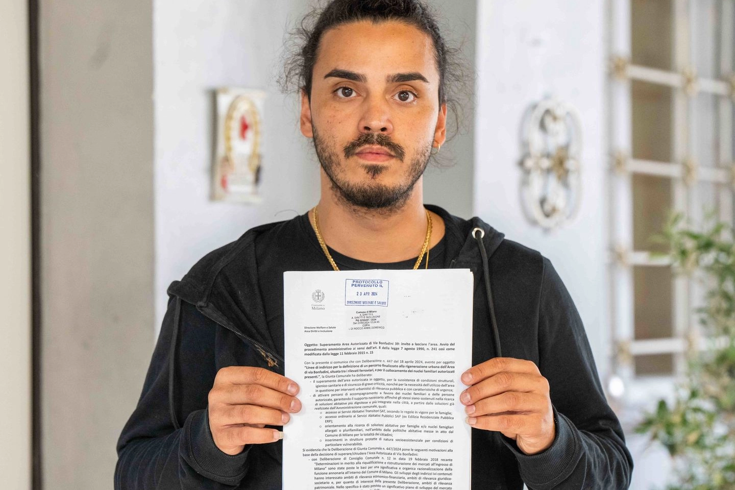 Domenico, residente del campo rom, mostra la lettera ricevuta