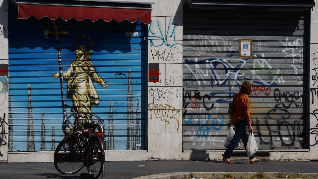 La saracinesca abbassata (e coperta di graffiti) di un negozio nel centro di Milano