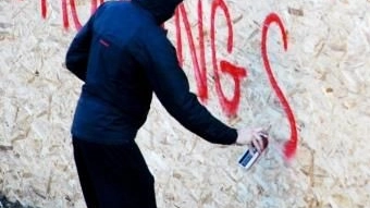 Un ragazzo scrive sul muro con la bomboletta spray (foto di archivio)