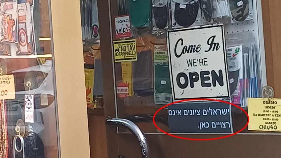 Il cartello appeso sulla porta della merceria di via Statuto, sotto il messaggio «No war» Il cartello appeso sulla porta della merceria di via Statuto, sotto il messaggio «No war»
