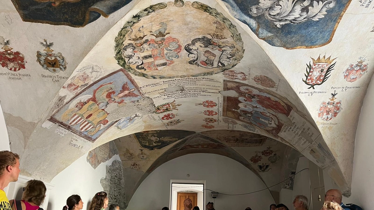 Turisti in visita a Palazzo Pretorio a Chiavenna con i suoi affreschi da ammirare Turisti in visita a Palazzo Pretorio a Chiavenna con i suoi affreschi da ammirare