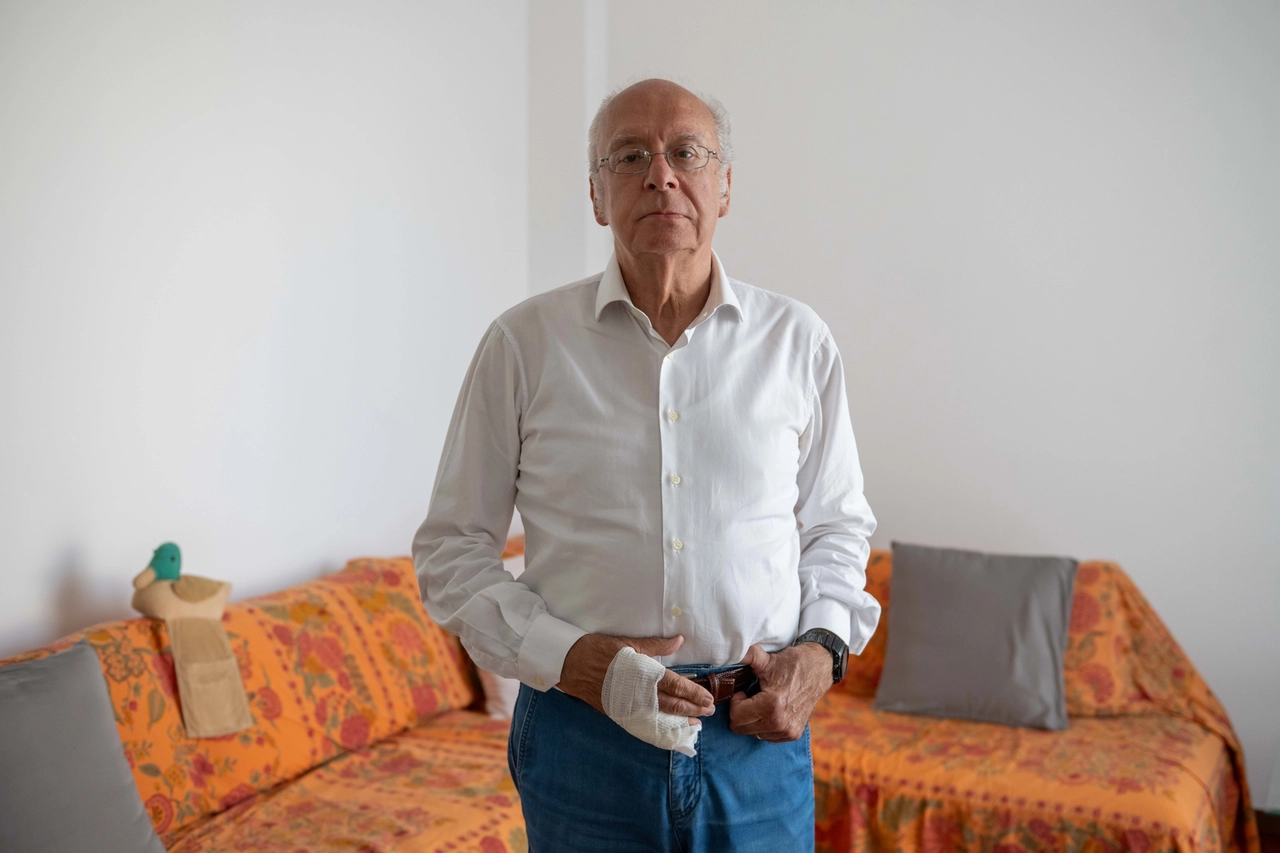 Massimo C., 75 anni, con il tutore al dito e la mano fasciata