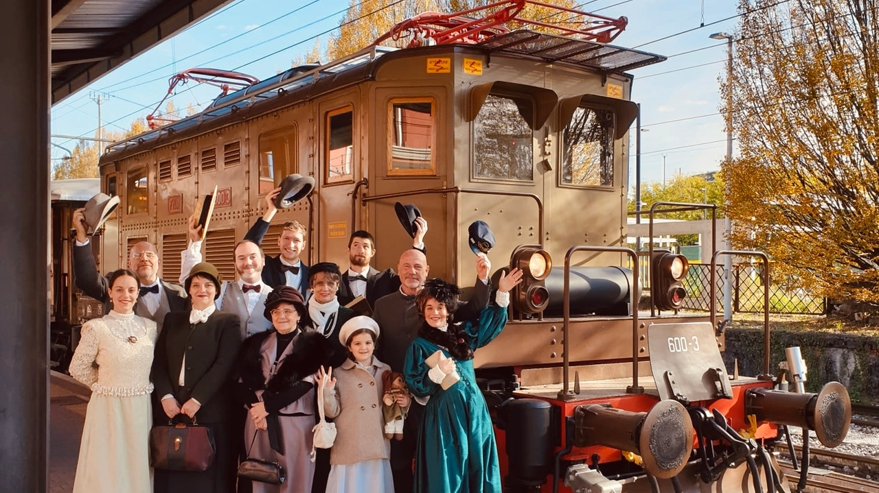 Un gruppo di figuranti in costume all'arrivo di una corsa del treno storico di Trenord
