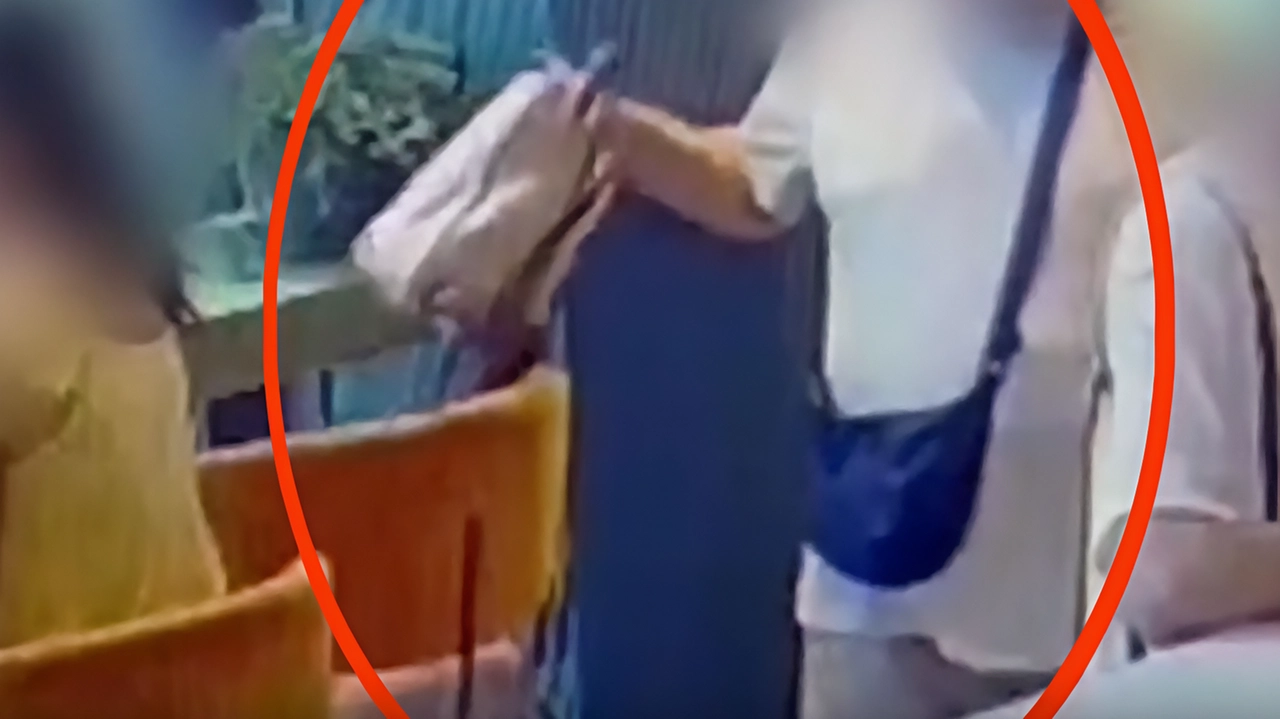 Il momento in cui il 56enne afferra la borsa appoggiata a una sedia mentre il suo complice sta distraendo il barista. Le vittime non si accorgono di nulla Il momento in cui il 56enne afferra la borsa appoggiata a una sedia mentre il suo complice sta distraendo il barista. Le vittime non si accorgono di nulla