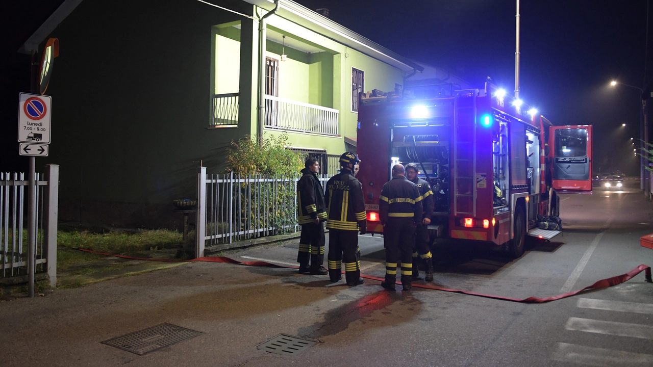 I vigili del fuoco fuori dalla palazzina di Mediglia dove è scoppiato l'incendio (foto Canali/Ansa)