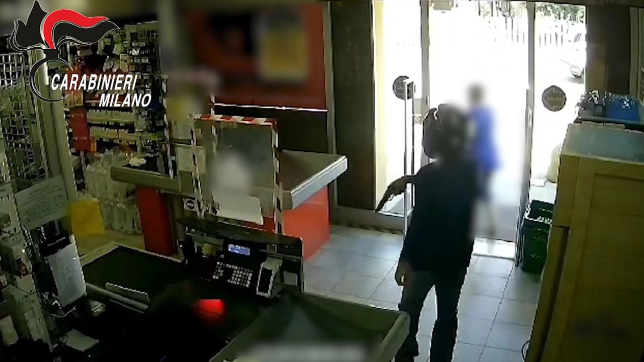 Frame video dei carabinieri: rapinatore in azione con la pistola in un supermercato