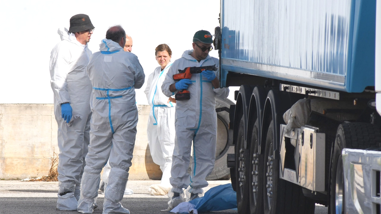 Gli operatori con le tute protettive al lavoro vicino al container Gli operatori con le tute protettive al lavoro vicino al container