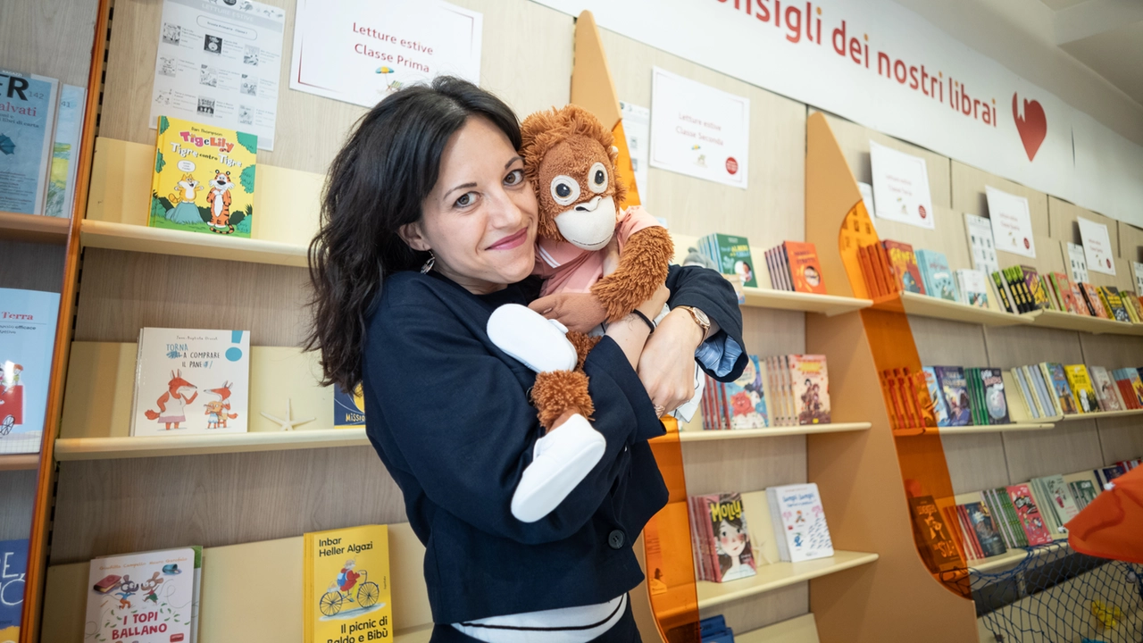 La libraia Silvia Neri con la mascotte della libreria Giovedì che la accompagna anche nelle scuole (Ansa/Davide Canella) La libraia Silvia Neri con la mascotte della libreria Giovedì che la accompagna anche nelle scuole (Ansa/Davide Canella)