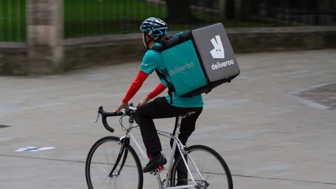 York, UK - September 19, 2016. A take away delivery cyclist from the increasingly popular hot food delivery company called Deliveroo speeding through city streets to deliver food to people's homes.