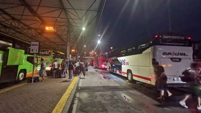 TUTTI PER TERRA A sinistra l’assalto agli autobus in partenza e sopra due ragazze  in attesa sul pavimento della stazione della M1