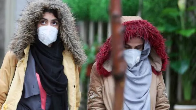 epa08230862 Iranian women wearing masks walk past in a street of Tehran, Iran, 20 February 2020. According to the Ministry of Health, two people diagnosed with coronavirus died in the city of Qom, central Iran. The disease caused by the virus (SARS-CoV-2) has been officially named COVID-19 by the World Health Organization (WHO).  EPA/ABEDIN TAHERKENAREH