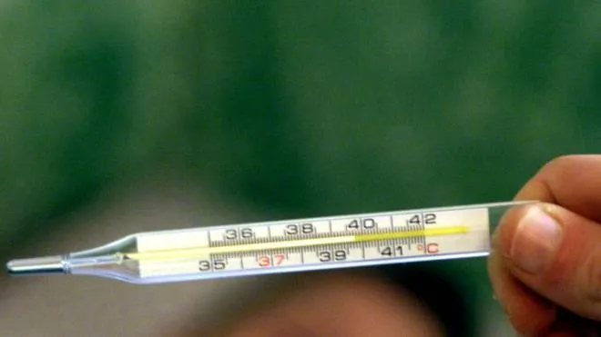 Un termometro misura la febbre in un malato di influenza.  FRANCO SILVI/ANSA/O