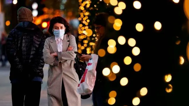 A pedestrian wearing a face mask or covering due to the COVID-19 pandemic, walk past Christmas-themed window display at Selfridges department store in central London on November 17, 2020. - Britain has been the worst-hit nation in Europe recording more than 50,000 coronavirus deaths from some 1.2 million positive cases. (Photo by Tolga Akmen / AFP)