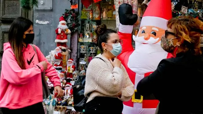 Passanti in mascherina anti covid avanti ad un negozio di articoli  di Natale nel centro storico di Napoli,  19 novembre  2020
ANSA / CIRO FUSCO
