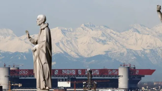 Le statue del Duomo e, sullo sfondo, San Siro, lo stadio che Inter e Milan vogliono abbattere in gran parte