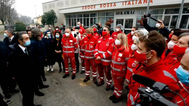 A sinistra il governatore Attilio Fontana con i volontari della Croce Rossa A destra il “cuore“ del memoriale con le parole “Resilienza“ “Comunità“ e “Ripartenza“ Sotto, residenti che non sono voluti mancare