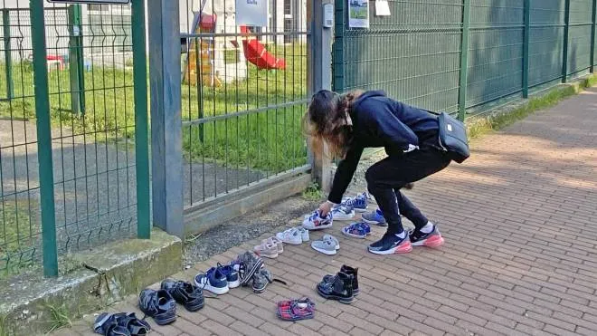 Le scarpe dei bambini lasciate davanti a scuola

