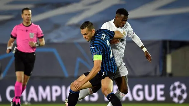 Atalanta's Brazilian defender Rafael Toloi (L) vies with Real Madrid's Brazilian forward Vinicius Junior during the UEFA Champions League round of 16 second leg football match between Real Madrid CF and Atalanta at the Alfredo di Stefano stadium in Valdebebas, on the outskirts of Madrid on March 15, 2021. (Photo by PIERRE-PHILIPPE MARCOU / AFP)