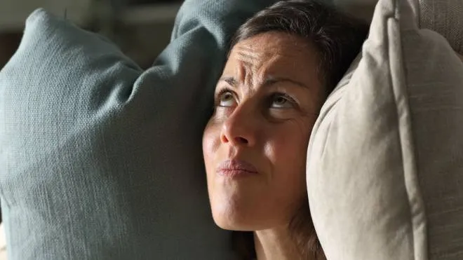 Lucidi Istockphoto - Annoyed adult woman suffering neighbour noise in the livingroom at night at home