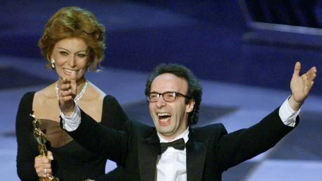 R03-OSCB10D:ENTERTAINMENT-OSCARS:LOS ANGELES,21MAR99 - Roberto Benigni celebrates winning the Oscar for Best Foreign film for his movie "Life Is Beautiful," as presenter Sophia Loren holds his award at the 71st Annual Academy Awards March 21. Benigni wrote, directed and starred in the movie.     
      Gary Hershorn   / ANSA-REUTERS / LI