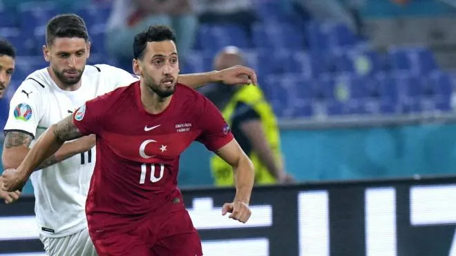 epa09263149 Hakan Calhanoglu (R) of Turkey in action during the UEFA EURO 2020 group A preliminary round soccer match between Turkey and Italy at the Olympic Stadium in Rome, Italy, 11 June 2021.  EPA/Alessandra Tarantino / POOL (RESTRICTIONS: For editorial news reporting purposes only. Images must appear as still images and must not emulate match action video footage. Photographs published in online publications shall have an interval of at least 20 seconds between the posting.)