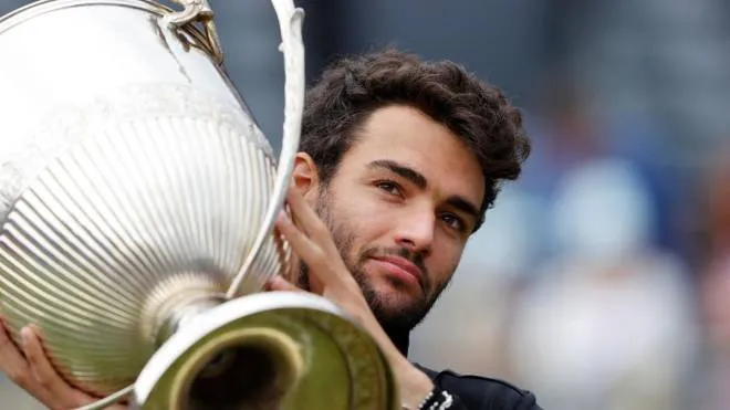 Italy's Matteo Berrettini carries the winners trophy after his victory over Britain's Cameron Norrie during their men's singles final tennis match at the ATP Championships tournament at Queen's Club in west London on June 20, 2021. (Photo by Adrian DENNIS / AFP)