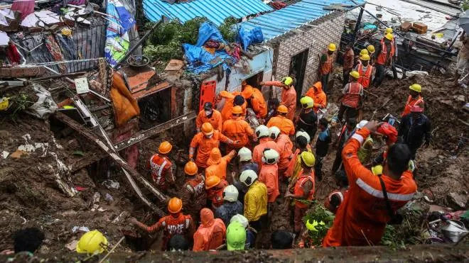 epa09352181 National Disaster Response Force (NDRF) personnel recover dead body from the rubble during a rescue operation in the aftermath of a landslide at a Bharat Nagar slum in Chembur, Mumbai, India, 18 July 2021. According to the police and municipal officials at least 22 people are dead and several others injured after a wall collapsed on some shanties in Chembur's Bharat Nagar area due to a landslide after heavy rainfall in the city.  EPA/DIVYAKANT SOLANKI