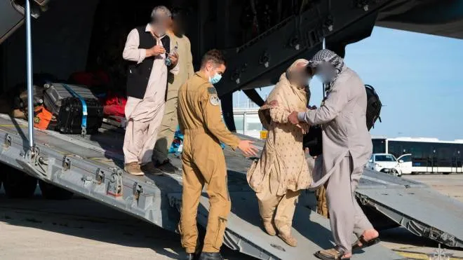 This handout photo taken and released by the French Etat-Major des Armees (Military Staff) shows people disembarking from a French Airforce 400M Atlas aircraft after being evacuated from Afghanistan as part of the operation "Apagan", at the Roissy-Charles de Gaulle airport, north of Paris, on August 25, 2021. (Photo by Eric CADIOU / various sources / AFP) / RESTRICTED TO EDITORIAL USE - MANDATORY CREDIT "AFP PHOTO /  ERIC CADIOU / ETAT-MAJOR DES ARMEES" - NO MARKETING - NO ADVERTISING CAMPAIGNS - DISTRIBUTED AS A SERVICE TO CLIENTS