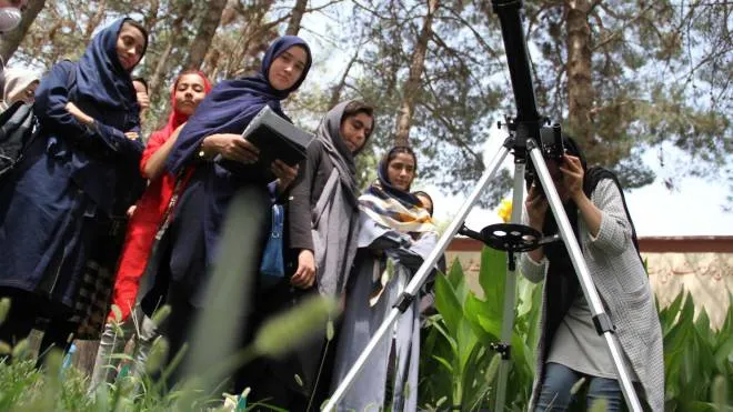epa09351758 Afghan girls observe the sky using a telescope at an institute in Herat, Afghanistan, 18 July 2021. A team of female students in Herat has won the World Astronomical Union Award. The girls' team is ranked first among 255 teams from 52 countries. These girls have been studying astronomy for two years and teach other girls in Herat schools. The World Astronomical Union will award a telescope and a number of astronomical instruments  EPA/JALIL REZAYEE