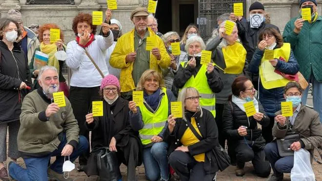 I residenti di San Siro davanti al Comune mostrano i cartellini gialli alla Giunta Sala. Sotto, il rendering Populous del nuovo stadio