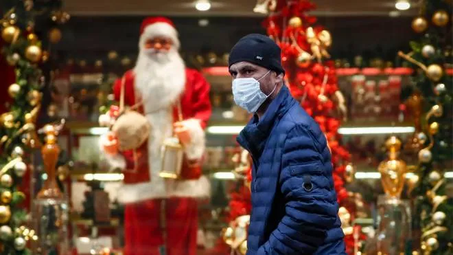 epa09578552 A man wearing a face mask walks in front of a shop window decorated for Christmas and New Year celebrations during the Covid-19 pandemic in Moscow, Russia, 12 November 2021. According to official data, 40123 new cases were registered in Russia in the last 24 hours, including 5183 in Moscow, caused by the SARS-CoV-2 coronavirus.  EPA/YURI KOCHETKOV