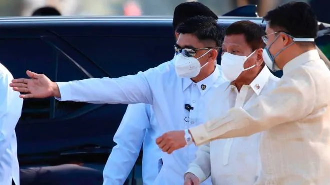 epa09660184 Filipino president Rodrigo Duterte (2-R)  wearing a facemask, is escorted during a ceremony to honor the ?death anniversary of national hero Jose Rizal at the Jose Rizal Park, Manila, Philippines, 30 December 2021. Filipinos honor Rizal whose death by exec?ution squad on 30 December 1896 helped inspire a Philippine revolution for independence against Spanish occupation.  EPA/FRANCIS R. MALASIG
