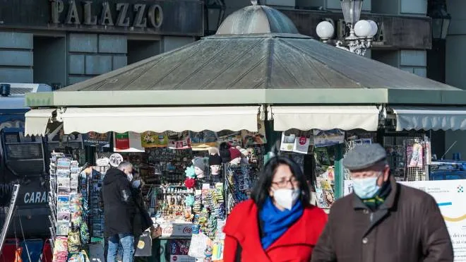 Due persone con la mascherina passeggiano davanti a un'edicola in piazza Castello, Torino, 18 gennaio 2022. ANSA/TINO ROMANO