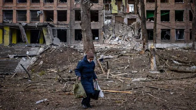A woman walks in front of a destroyed building after a Russian missile attack in the town of  Vasylkiv, near Kyiv, on February 27, 2022. - Ukraine's foreign minister said on February 27, that Kyiv would not buckle at talks with Russia over its invasion, accusing President Vladimir Putin of seeking to increase "pressure" by ordering his nuclear forces on high alert. (Photo by Dimitar DILKOFF / AFP)