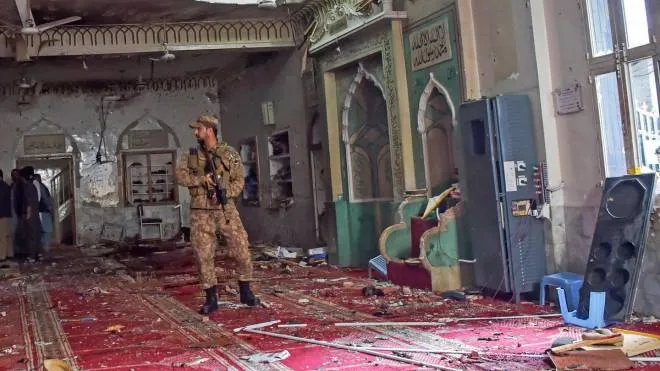 A soldier stands guard inside a mosque after a bomb blast in Peshawar on March 4, 2022. - At least 30 people were killed and 56 wounded in a huge blast at a mosque in the northwestern Pakistani city of Peshawar, a hospital official said on March 4. (Photo by Abdul MAJEED / AFP)