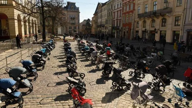In this picture taken on March 18, 2022, 109 empty strollers are seen placed outside the Lviv city council during an action to highlight the number of children killed in the ongoing Russia's invasion of Ukraine. (Photo by Yuriy Dyachyshyn / AFP)