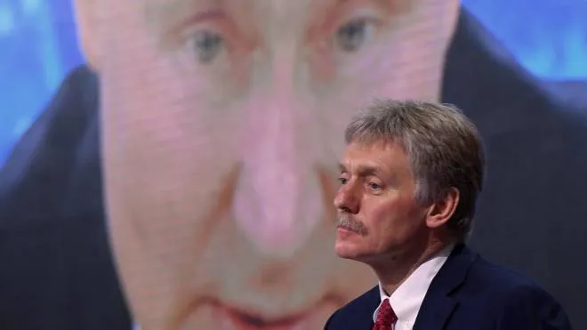 (FILES) In this file photo taken on December 17, 2020, Kremlin spokesman Dmitry Peskov sits in front of a screen displaying Russian President Vladimir Putin addressing his annual press conference via a video link from the Novo-Ogaryovo state residence, at the World Trade Centre's congress centre in Moscow. - Russia would only use nuclear weapons in the context of the Ukraine conflict if it were facing an "existential threat," Kremlin spokesman Dmitry Peskov told CNN International on March 22, 2022. (Photo by NATALIA KOLESNIKOVA / AFP)
